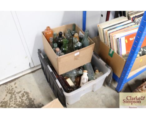 Two boxes containing various vintage glass and stoneware bottles , varying in condition and age