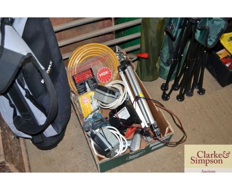 A box containing camera tripod, battery charger and sander