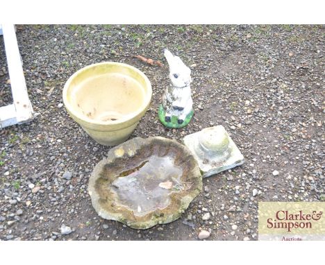 A planter, a concrete bird bath and statue in the form of a rabbit 
