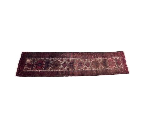 A long red, black, and brown rug featuring a captivating array of shapes, including snowflakes, squares, staircases, and more