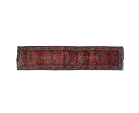Hand knotted, long deep richly colored field with multiple gray accented medallions and fringed carpet runner. Issued: 20th c