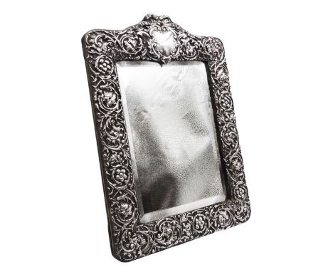 Edwardian silver mounted dressing table top mirror, of rectangular form, the frame embossed with vacant reserve, flower heads