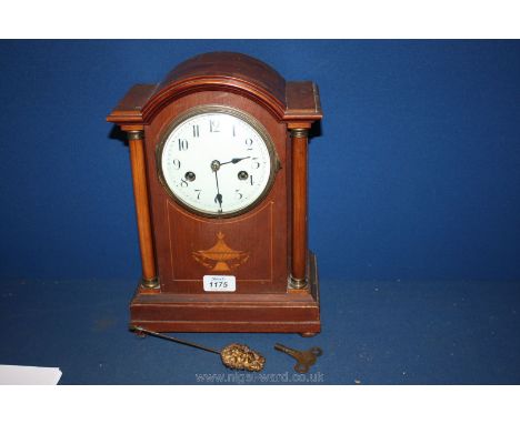 A Mahogany cased Clock with enamel face, having two train movement and two pendulums, one having gilt metal cherub face.
