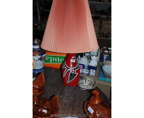 A pottery based Table Lamp, the base deep crimson ground with black, green and white depictions of stylised ivy foliage, with