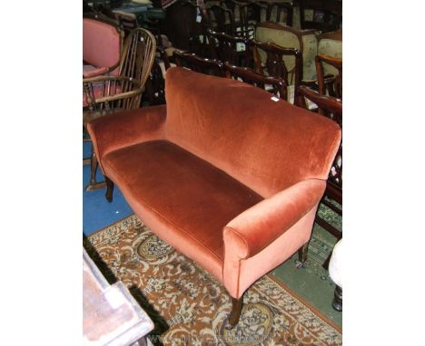 An amber velvet upholstered two seater Salon Sofa on shaped legs with ceramic castors.