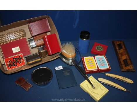 A box of interesting miscellanea including boxed Lloyds Bank money box, hip flasks, letter opener, card games, dressing table