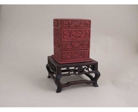 An Oriental cinnabar stacking trinket box on associated hardwood stand 