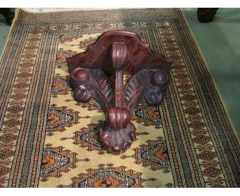 A late Victorian carved mahogany clock bracket supported by Prince of Wales feathers.
