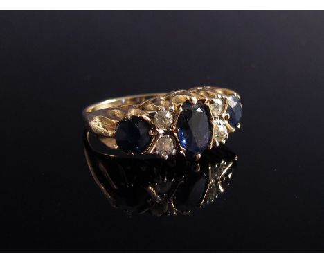 A gold sapphire and diamond ring the centre oval cut blue sapphire flanked by two round cut diamonds and single sapphire   