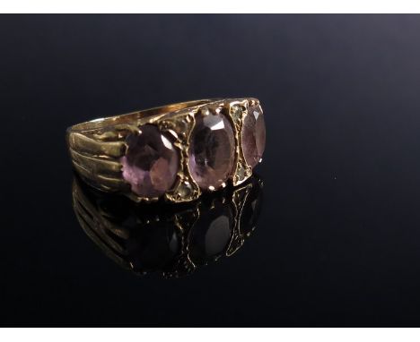 An amethyst three stone ring in gold shank 