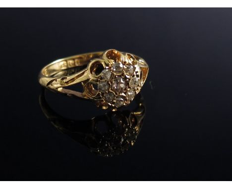 An 18ct gold diamond ring of daisy form with open shoulders   