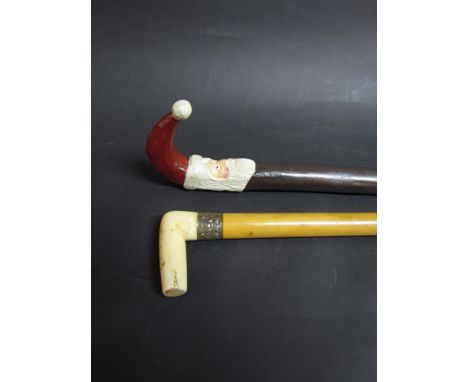 A walking cane with crooked handle in the form of Father Christmas, and an Oriental walking stick with malacca shaft, white m