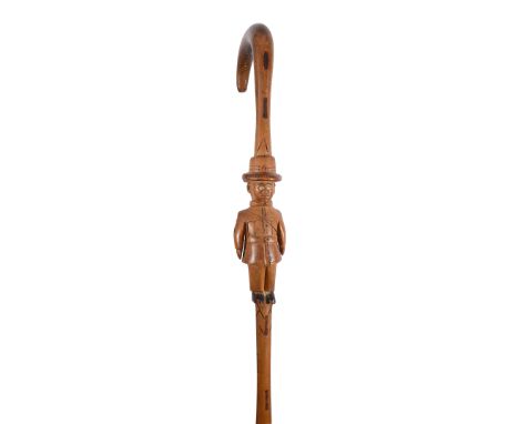 An early 20th century tribal carved walking stickpossibly east Africanthe stem carved with the figure in colonial military dr