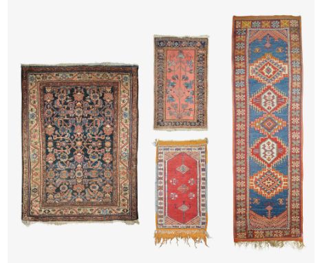 Four early 20th century Persian rugscomprising a Hamadan rug with central herati field, a small Hamadan rug, a small Turkish 