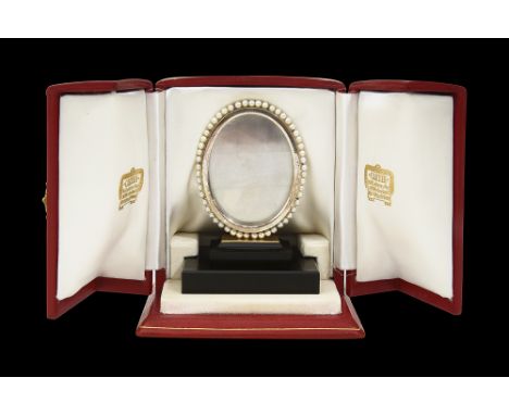 Cartier, Paris. A silver, gold, cultured pearl and black onyx picture frame c.1950the oval silver glazed frame with cultured 