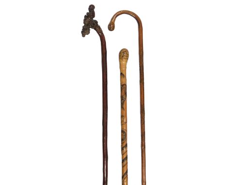 A late 19th century Chinese carved walking stick and two Japanese walking sticks first the terminal pierced and carved with t