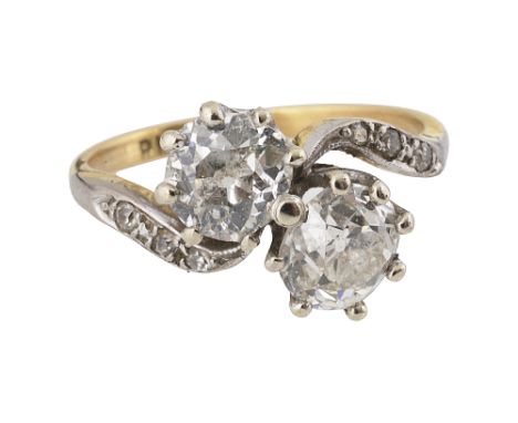 A diamond two stone cross-over ringthe old brilliant-cut diamonds obliquely-set to the 'S' scroll diamond-set shoulders, to t