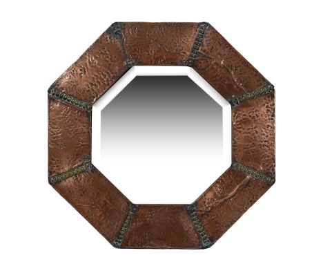 An Arts and Crafts octagonal copper wall mirrorC.1900the bevelled mirror plate within a sectional frame divided by brass bobb