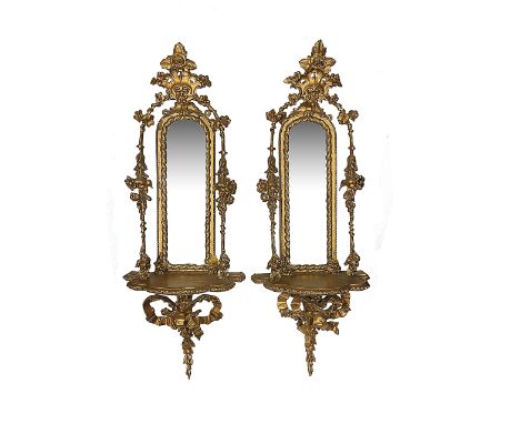 A pair of Victorian giltwood and gesso mirror backed wall bracketslate 19th centurythe rocaille and flowerhead crestings abov