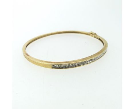 A narrow 9ct gold hinged Bangle, the front set with nineteen small diamond points, 5.5cmx4.8cm internal, 7.3g. 