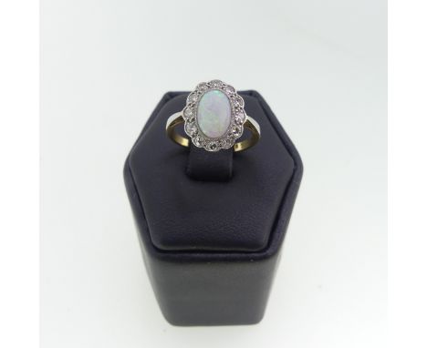 A small opal and diamond cluster Ring, the central cabochon opal approx 8.3mm long, surrounded by twelve small diamond points