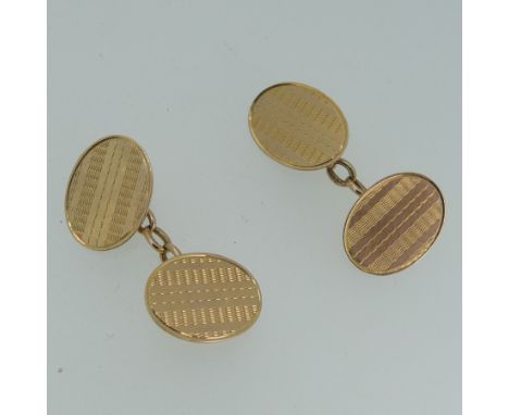 A pair of 15ct yellow gold oval Cufflinks, with engine turned decoration, chain between, 6.4g. 