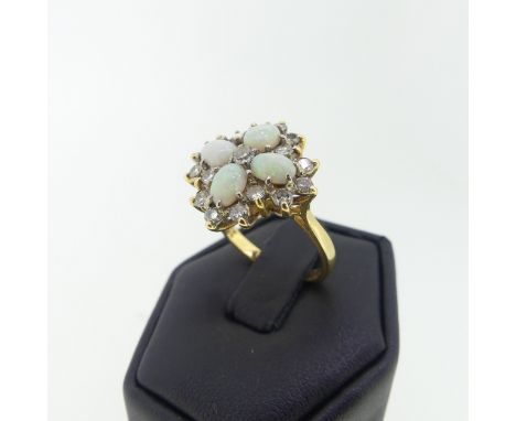 An opal and diamond cocktail Ring,&nbsp;with four oval cabochon opals, each 5.5mm long, set in a cross with diamond centre an