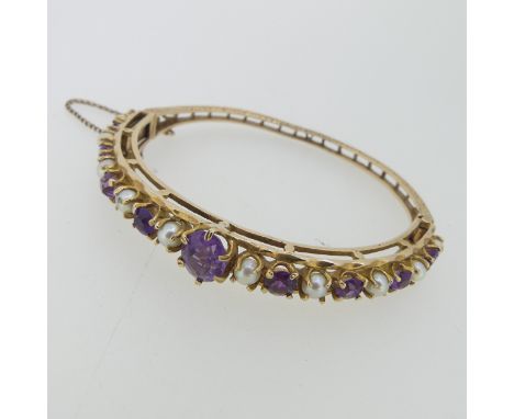 A 9ct yellow gold hinged Bangle, the front with claw set central oval facetted amethyst with alternate cultured half pearls a