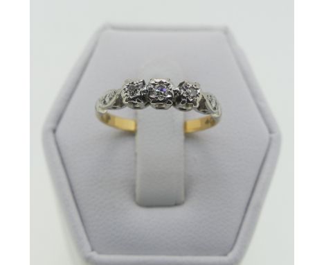 A small three stone diamond Ring, illusion set in 18ct yellow gold and platinum, Size K, 2.1g. 