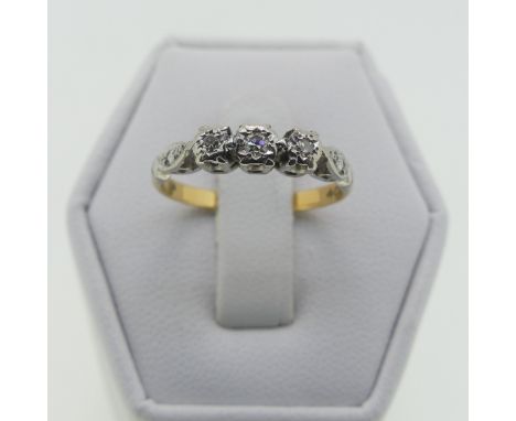 A small three stone diamond Ring, illusion set in 18ct yellow gold and platinum, Size K, 2.1g. 