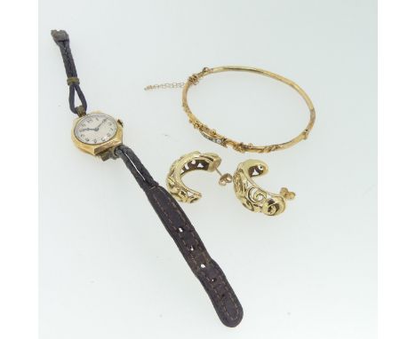A narrow 9ct gold hollow hinged Bangle, the front with stylised foliate decoration set seed pearls and turguoise,&nbsp;as fou