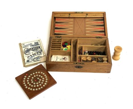 An early 20th century games compendium, comprising lead horses; gaming counters; Bezique cards; draughtsmen; treen dice shake