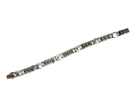 A Scandinavian silver and pearl bracelet (in need of repair), openwork panels set with three seed pearls alternating with bli