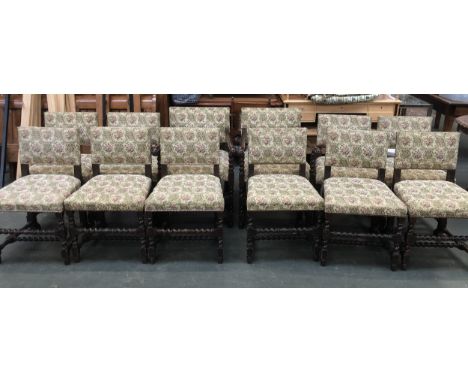 A set of twelve oak dining chairs (two carvers), upholstered in a tapestry style print, close nailed, on barley twist front l