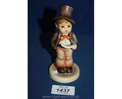 A Goebel Hummel figure of a little boy singing from sheet music.