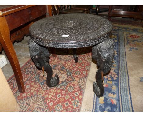 An ebonised circular Eastern occasional Table, the top with a nicely detailed central carved scene with Thai type figure flan