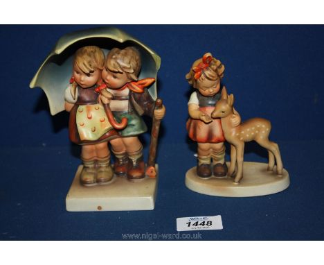 Two Goebel Hummel figures of two children under an umbrella and a little girl with a deer, finger chipped.