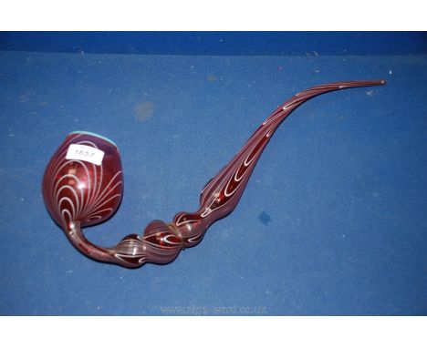 A large red glass display smoking pipe.