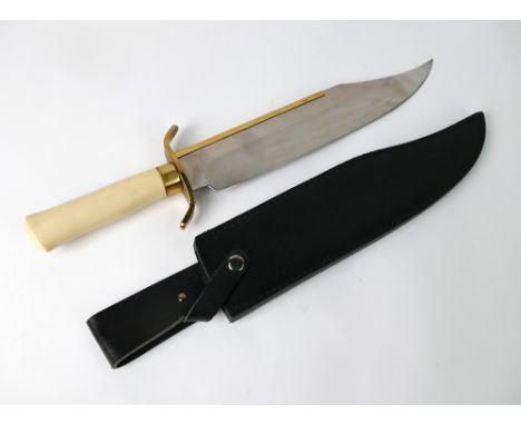 A Bowie knife with 13 1/2" blade, with brass covered spine, with brass S shaped cross guard and ivorine handle.  Overall leng