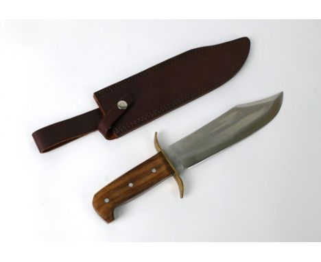 A Bowie knife with 10" blade, brass S shaped cross guard and wooden scales.&nbsp; Overall length 37.5 cm with leather sheath.
