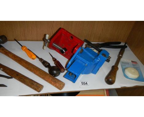 A shelf of small tools and a bench vice. 