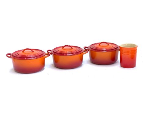 Three Le Creuset cast iron and enamel casserole pots, 23cmD; together with a Le Creuset ceramic kitchen jar 