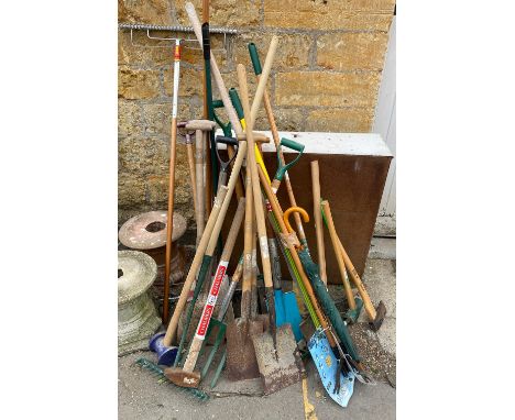 A large quantity of garden tools to include spades, shovels, pickaxe, axes, sledgehammer, rakes, etc 