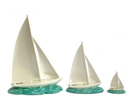 A set three 1930s Poole Pottery graduating sailing boats, 39cmH, 26.5cm and 11cmH, the two smaller with wall plaque screw hol