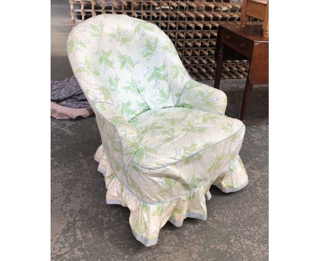A Victorian button upholstered bedroom chair with loose cover on carved and turned legs with brass caps and ceramic casters, 