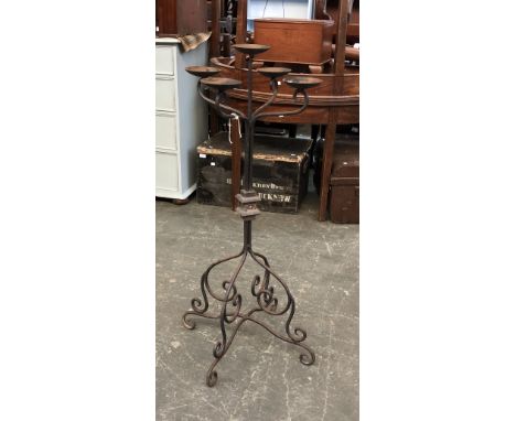 A wrought iron floor standing candle holder with five sconces, 108cmH; together with a further wrought iron candlestick holde