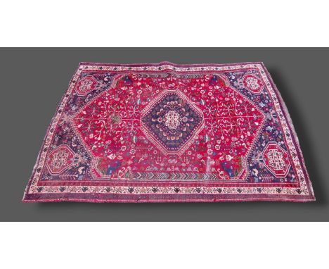 A Northwest Persian woollen carpet with an all-over design upon a red, blue and cream ground within multiple borders, 205cms 
