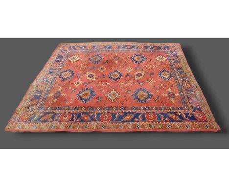 A Northwest Persian woollen carpet with an all-over design upon a terracotta and blue ground within multiple borders, 274cms 