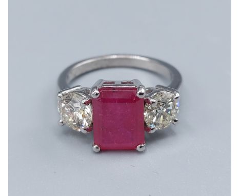 A Platinum three stone ring set with a central recangular Ruby flanked by Diamonds, claw set, 5.6gms, ring size K