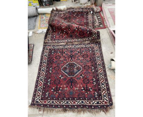A SMALL VINTAGE RED PATTERNED FRINGED RUG 